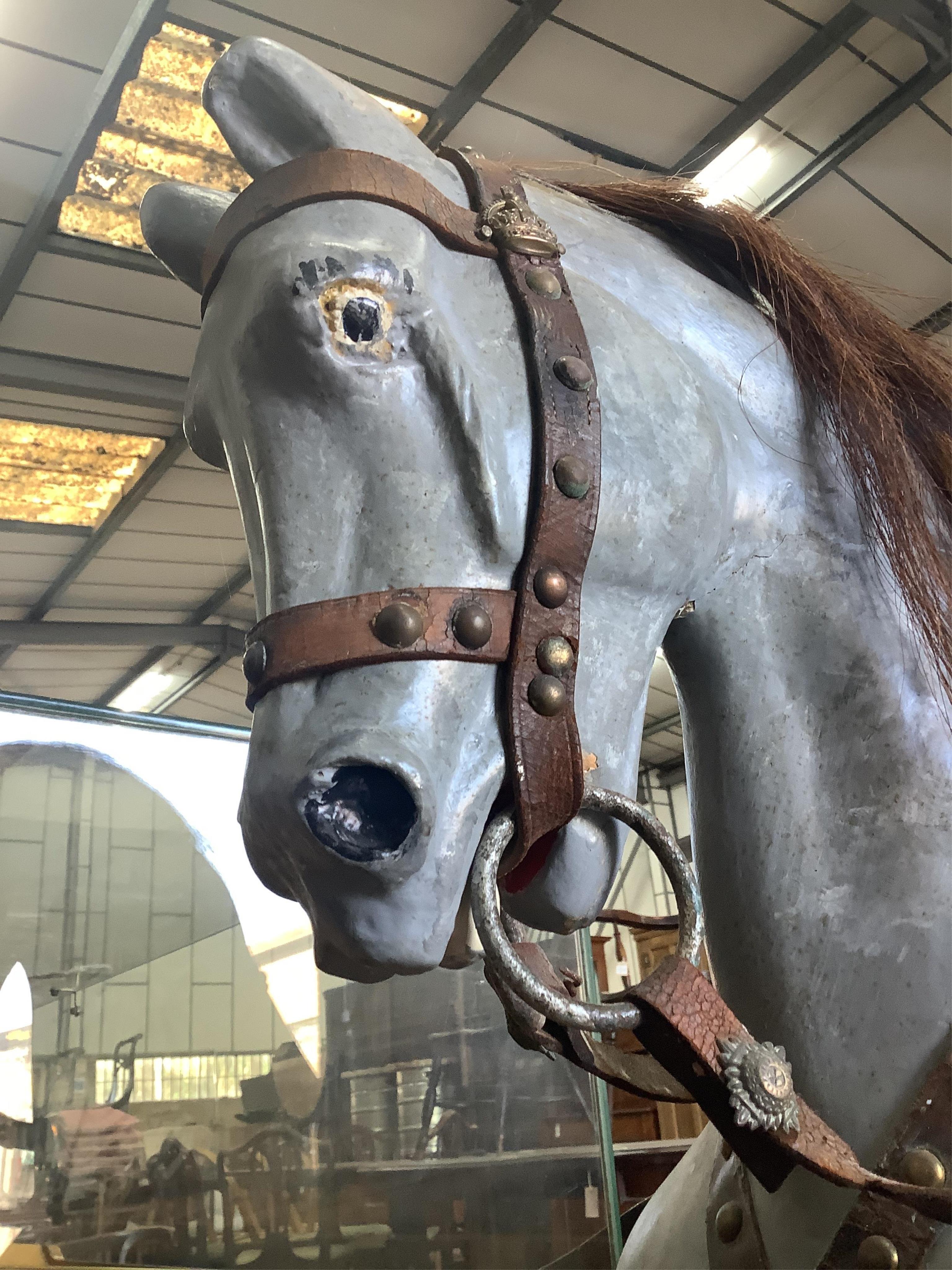 An early 20th century dapple grey rocking horse on pine safety frame, length 136cm, height 108cm. Condition - fair, later painted